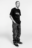 Studio portrait of a man in a black Stüssy t-shirt, relaxed stance, styled in loose-fit jeans and sneakers — clean product integration in AI fashion