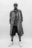 Confident AI-generated portrait of a model in oversized Bareen coat, striped shirt, and chunky sneakers, standing against a plain white backdrop