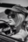 Black and white close-up of a woman wearing aviator sunglasses and a cap, seated in a vintage convertible, shot with cinematic AI aesthetic